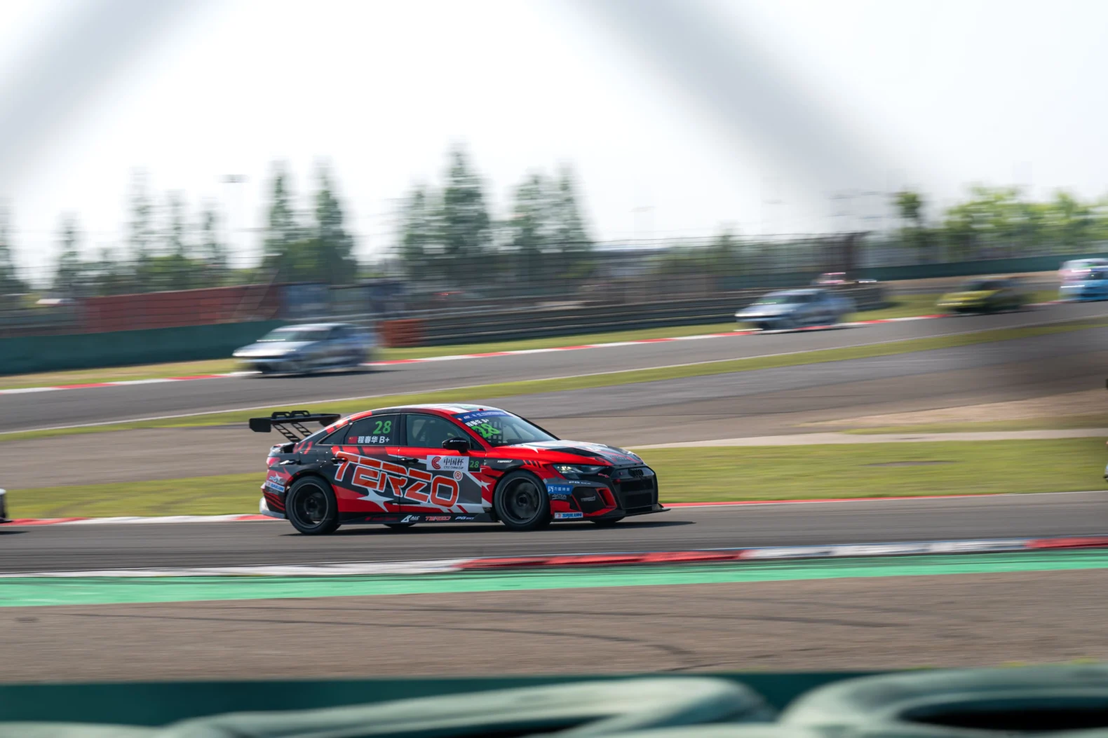 Complete TERZO-liveried touring car carrying speed through a corner