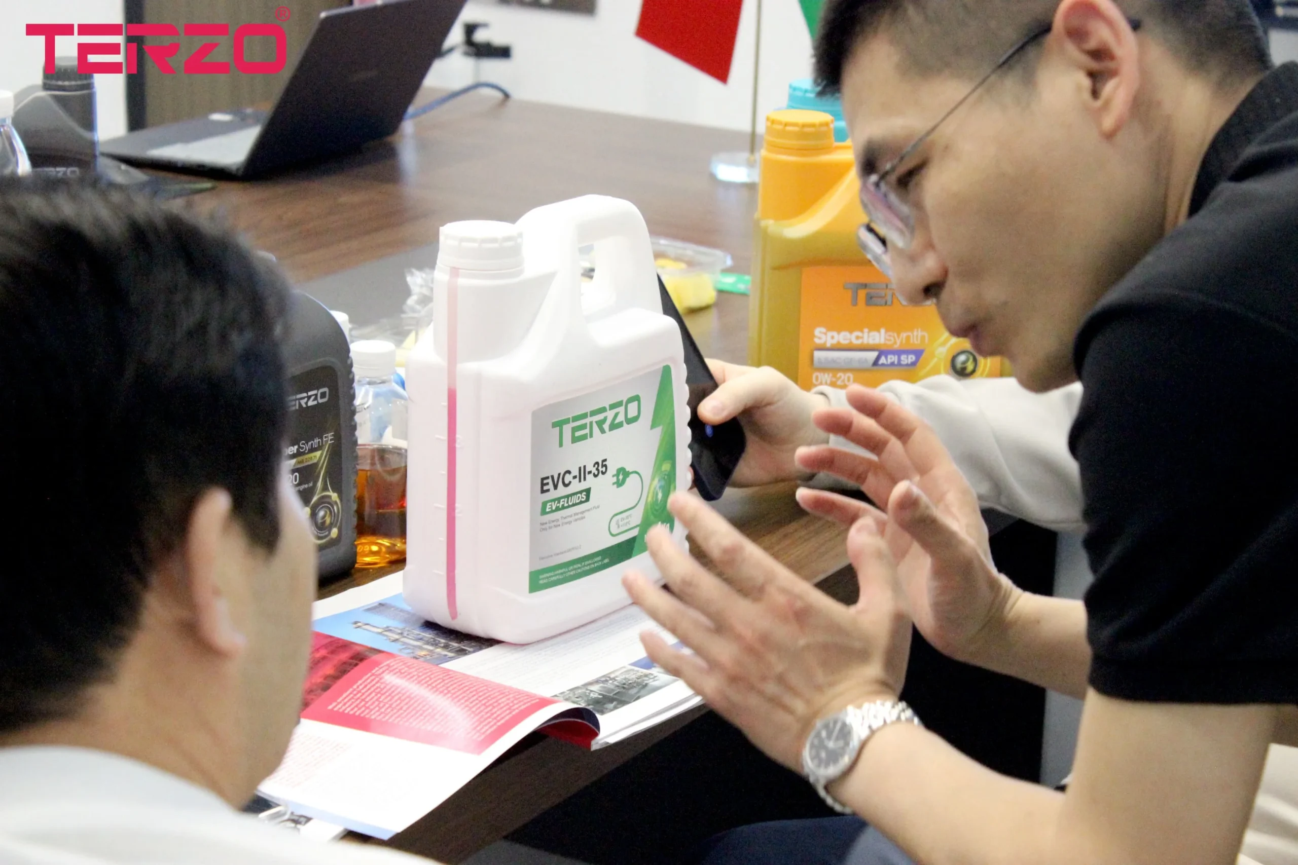 TERZO team discussing lubricant product samples and technical documents with customers